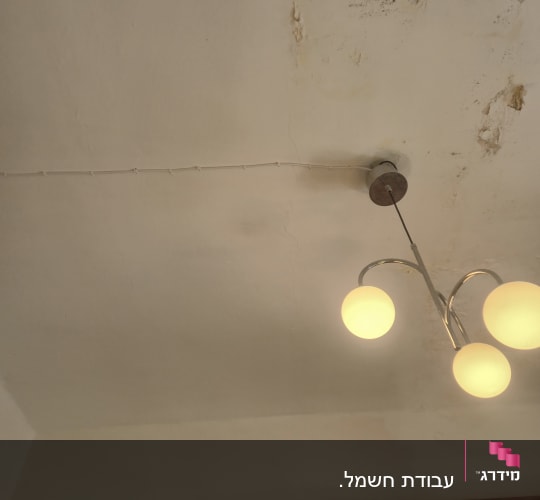 מנורה תלויה על תקרה עם סימני רטיבות